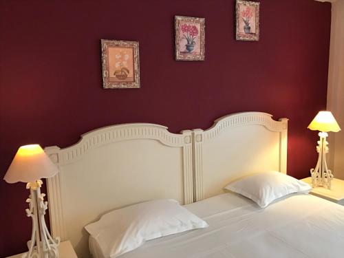 a bedroom with a white bed with two lamps at Hotel Le Festival in Cannes
