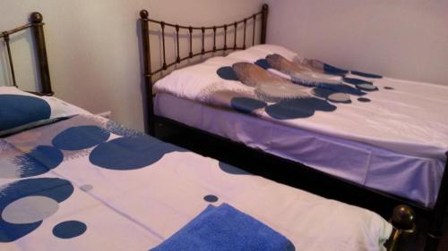 two twin beds with blue and white sheets at Apartment on Tabukashvili Street in Tbilisi City