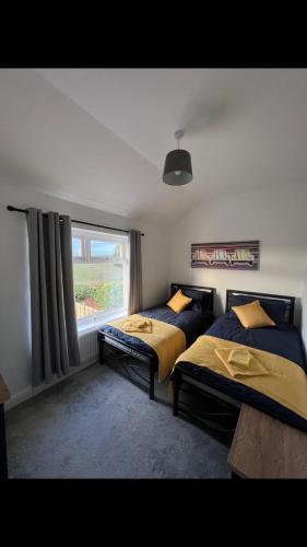 a bedroom with two beds and a window at The house with a view in Warrington