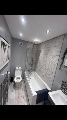 a bathroom with a tub and a toilet and a sink at The house with a view in Warrington