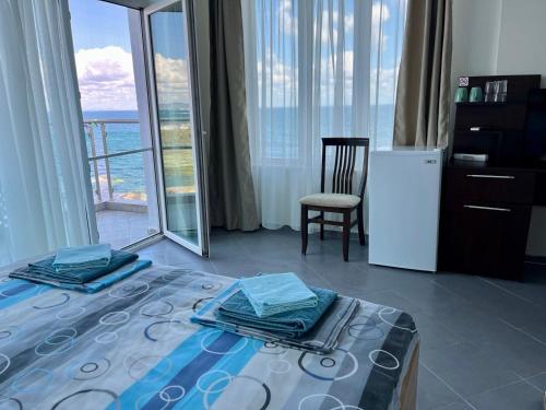 a bedroom with a bed and a chair and a refrigerator at Вила Арапя in Tsarevo