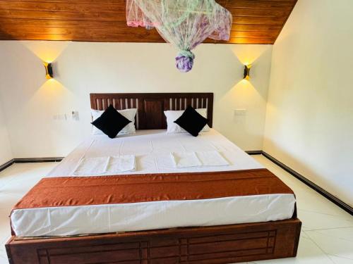 a bedroom with a large bed in a room at Sigiriya Chena Villa in Sigiriya