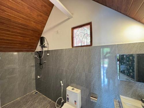 a bathroom with a toilet and a window at Sigiriya Chena Villa in Sigiriya