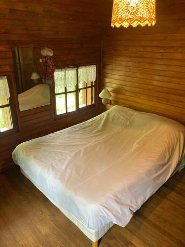 a bedroom with a white bed in a wooden wall at Refuge-style chalet Mountain view in Colmars