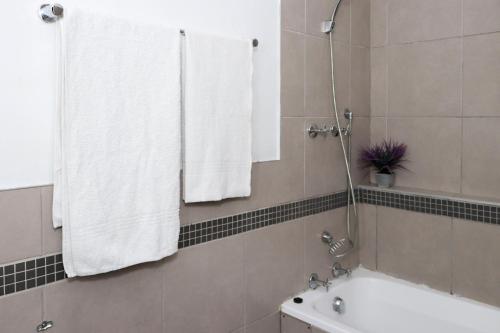 a bathroom with a shower and a tub and a sink at The Orange Corner III in Johannesburg