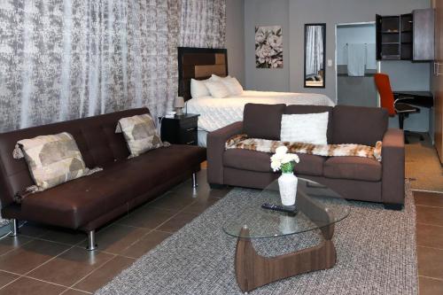 a living room with two couches and a bed at The Orange Corner III in Johannesburg