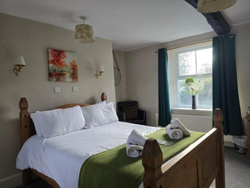 a bedroom with a bed with towels on it at Littledean House Hotel in Cinderford