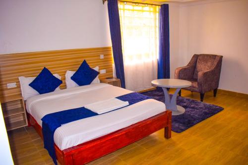 a bedroom with a bed and a chair and a table at Himaya Garden in Lanet