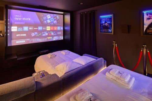 a hotel room with two beds and a large screen at Appartement Cinéma Ecran géant & Dolby Atmos in Niort