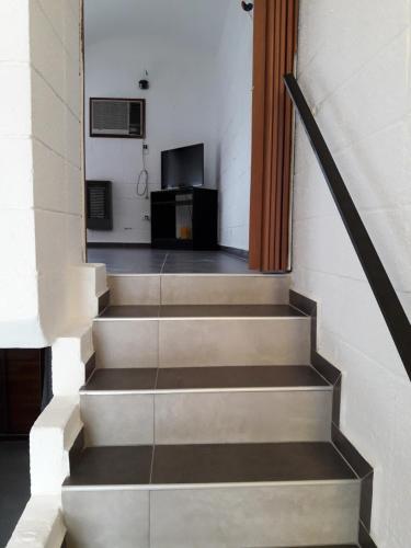 una escalera que conduce a una habitación con TV en La Chicharra en Villa Carlos Paz