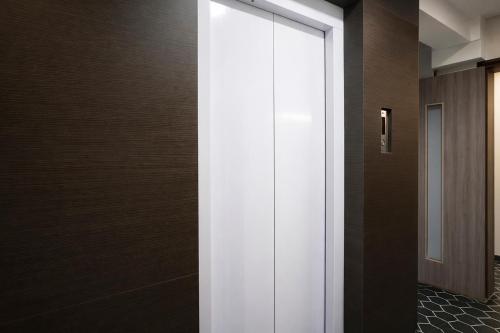 a corridor with a white door in a building at FabHotel Samrath in Mumbai