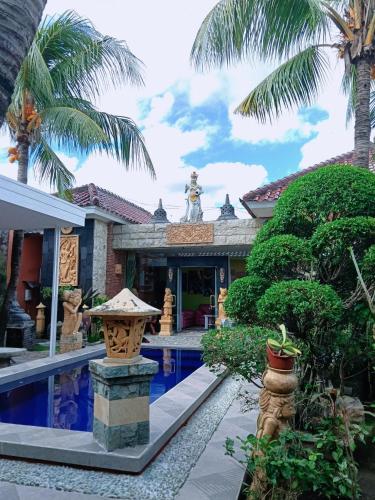 a house with a swimming pool and palm trees at Umah kampung8 in Mataram