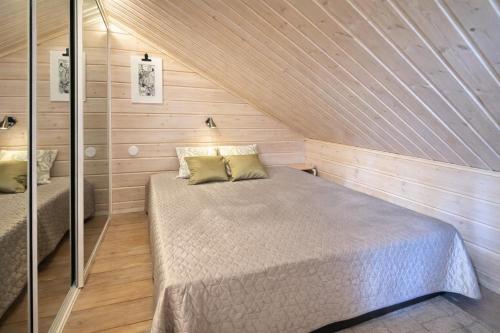 a small bedroom with a bed in a wooden wall at Northern Lights Lodge in Kittilä