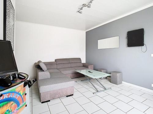 a living room with a couch and a tv at Le refuge de Gavrelle - Maison 6 lits, Wifi in Gavrelle