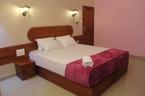 a bedroom with a bed with a white towel on it at Horn Bill Cottage in Thekkady