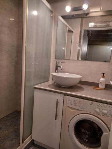 a bathroom with a sink and a washing machine at maison 100 m de la plage à pieds in Portiragnes