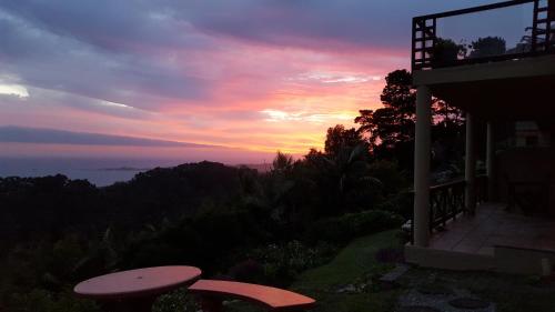 a sunset over the ocean from a house with a table at 110 Bay View in Brenton-on-Sea