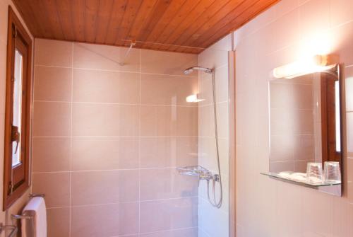 a bathroom with a shower with a glass door at Ostau dera nheu in Les