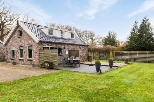 a brick house with a patio in the yard at 't Skoallehus in Steggerda