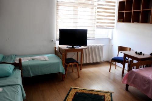a living room with a tv and a couch and a table at Rooms Karadjordje in Belgrade