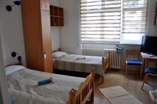 a small room with two beds and a television at Rooms Karadjordje in Belgrade