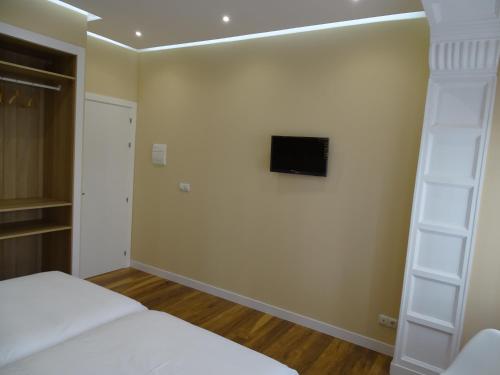 1 dormitorio con 1 cama y TV en la pared en Urban Burgos, en Burgos