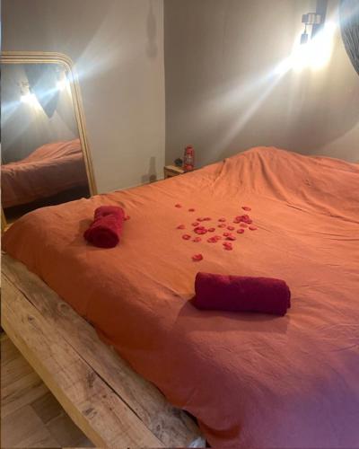 a bed with red rose petals on it at Chassepierre's Soul in Chassepierre