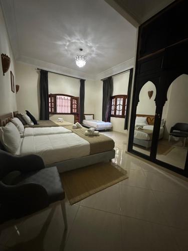 a large bedroom with two beds and a mirror at Fekhara CC in Marrakesh
