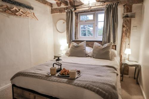 a bedroom with a bed with a tray of food on it at The Old Post Box in Holton