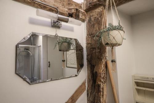 a mirror hanging on a wall with a wooden pole at The Old Post Box in Holton