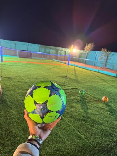 a person holding a soccer ball in a field at Private farm Pool games Ras alkhaimah in Maghribīyah