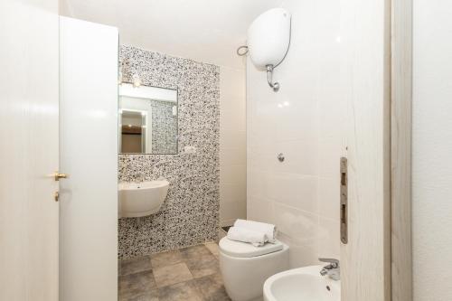 a bathroom with a toilet sink and a mirror at Casa Ale in centro in Santa Maria Navarrese