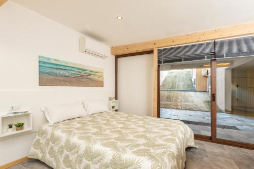 a bedroom with a bed and a large window at Casa Ale in centro in Santa Maria Navarrese