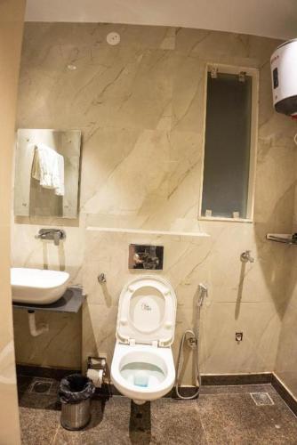 a bathroom with a toilet and a sink at Comfy GK Residency in New Delhi