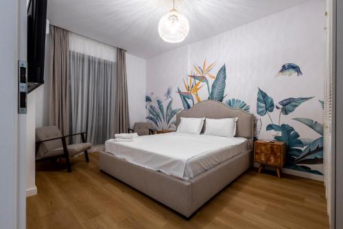 a bedroom with a bed and a mural of plants at Velora Apartments in Năvodari
