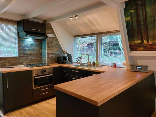 a kitchen with a wooden counter top and a sink at Chalet Het Hulstje 2 in Durbuy