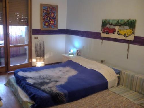 een slaapkamer met een bed met een blauwe deken bij Non Solo Breakfast in Imola