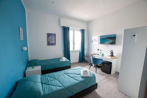 a hotel room with two beds and a desk at Mhometredici Guest House - Camere moderne a Sestu vicino aeroporto Cagliari e Policlinico in Sestu