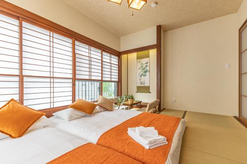 a bedroom with a large bed with an orange blanket at KOKORO INN TOKYO 5-minute walk to Senso-ji Temple Four-story private house with two bathrooms luxury stay in Tokyo