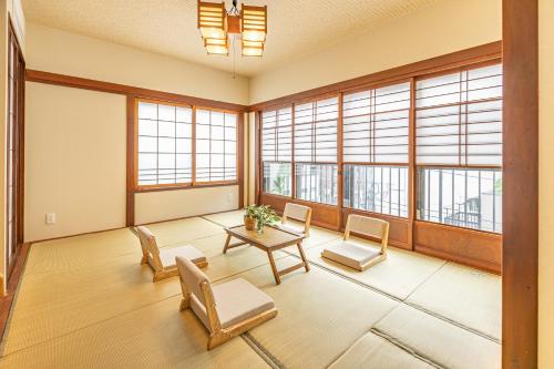 a large room with a table and chairs and windows at KOKORO INN TOKYO 5-minute walk to Senso-ji Temple Four-story private house with two bathrooms luxury stay in Tokyo
