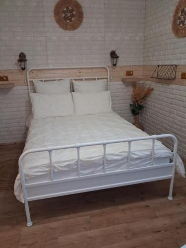 a bed with white sheets and pillows in a room at Studio The Cozy Corner in Timişoara
