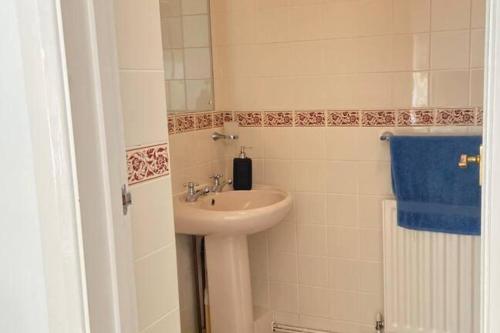 a bathroom with a sink and a blue towel at House - Free Parking & Sea Views in Brighton & Hove