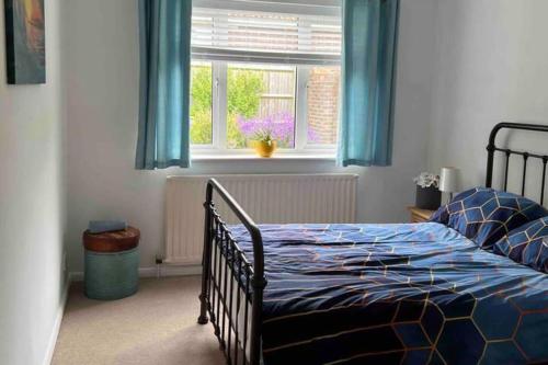 a bedroom with a bed with blue curtains and a window at House - Free Parking & Sea Views in Brighton & Hove