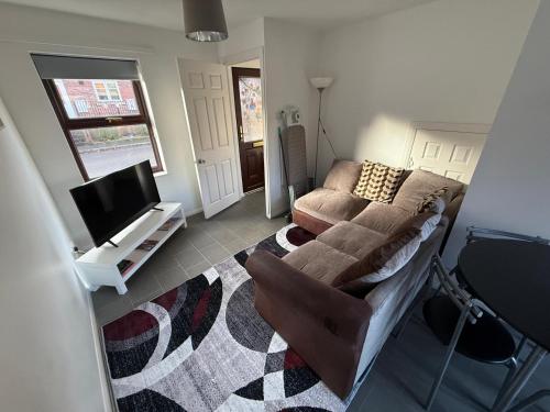 a living room with a couch and a tv at 2 bed house, walking distance Shrewsbury centre in Shrewsbury