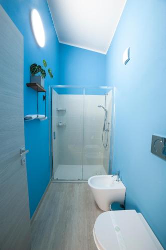 a blue bathroom with a toilet and a shower at Mhometredici Guest House - Camere moderne a Sestu vicino aeroporto Cagliari e Policlinico in Sestu