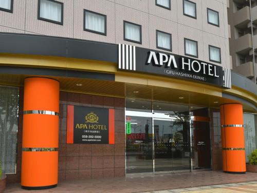 a hotel with orange columns in front of a building at APA Hotel Gifu Hashima Ekimae in Hashima