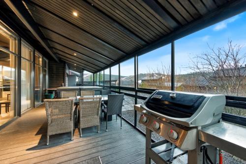a deck with a grill and a table and chairs at Villa Solarsuite Incl WiFi, Jacuzzi for extra fee in Himos