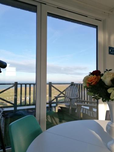 a table with a vase of flowers and a view of the ocean at La Naturelle Duplex 90 in Wimereux