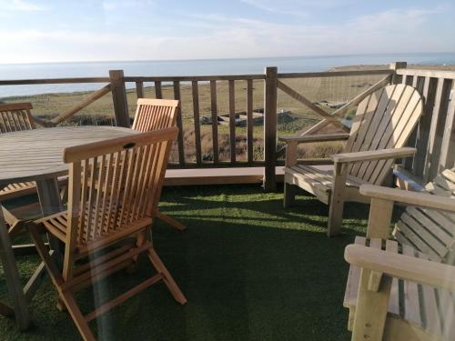 a deck with a table and chairs and the ocean at La Naturelle Duplex 90 in Wimereux