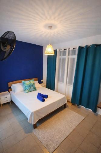 a bedroom with a bed with a blue wall at Horizon Blue GRAND Var in Rodrigues Island